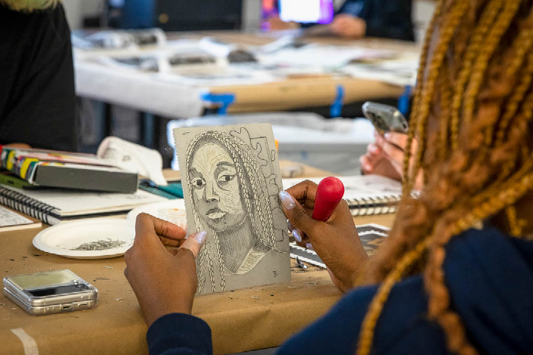 Students holding up a lino-cut project